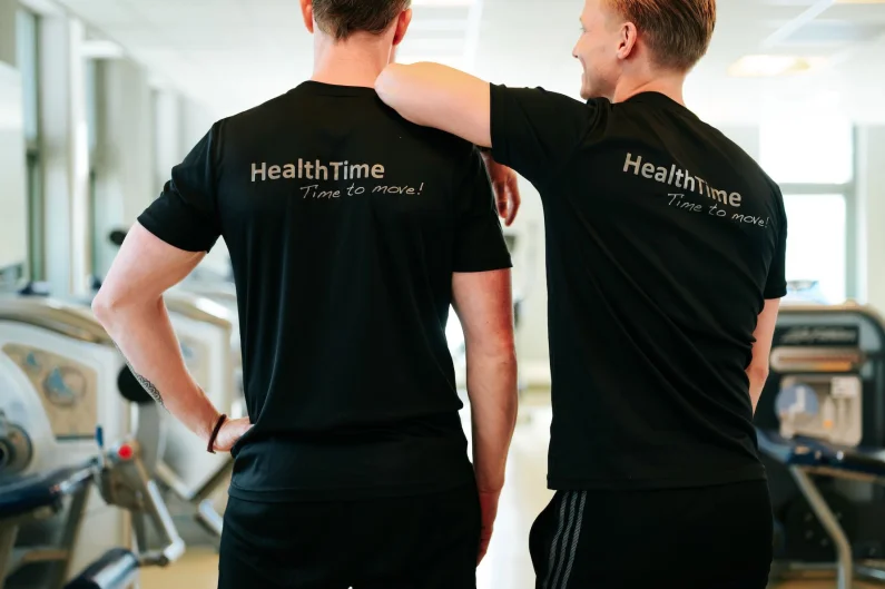 Health time trainers staan met de rug naar de camera, klaar om hun klanten te ontvangen.